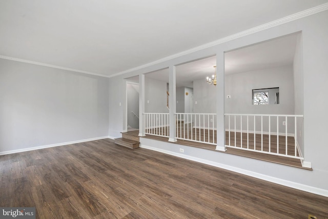 unfurnished room featuring baseboards, a chandelier, crown molding, stairs, and wood finished floors