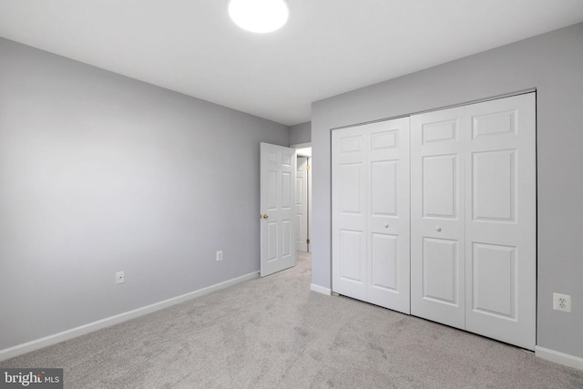 unfurnished bedroom featuring a closet, baseboards, and carpet floors