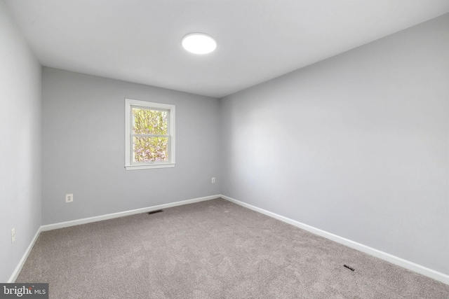 carpeted empty room with baseboards and visible vents