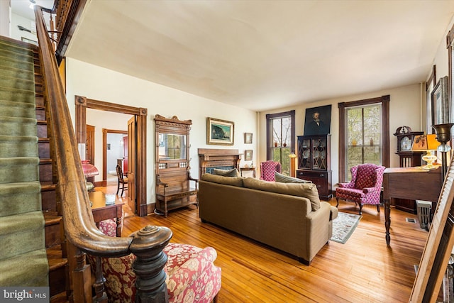 living room featuring hardwood / wood-style floors, a fireplace, and stairs