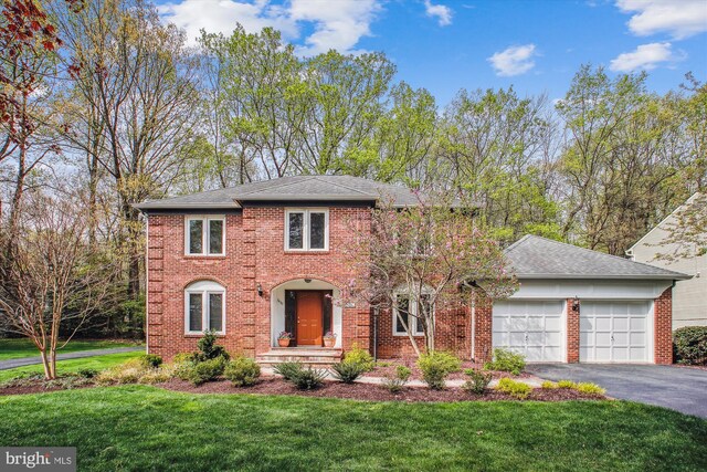 3430 Valewood Dr, Oakton, VA 22124 - colonial inspired home featuring a front yard, an attached garage, brick siding, and aphalt driveway