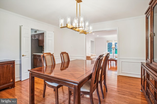3430 Valewood Dr, Oakton, VA 22124 - dining area with a notable chandelier, a decorative wall, ornamental molding, light wood finished floors, and a wainscoted wall