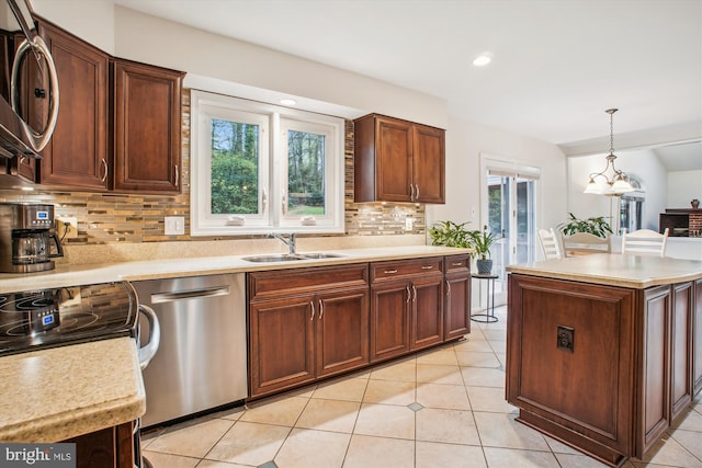 3430 Valewood Dr, Oakton, VA 22124 - kitchen with light tile patterned floors, dishwasher, light countertops, hanging light fixtures, and backsplash