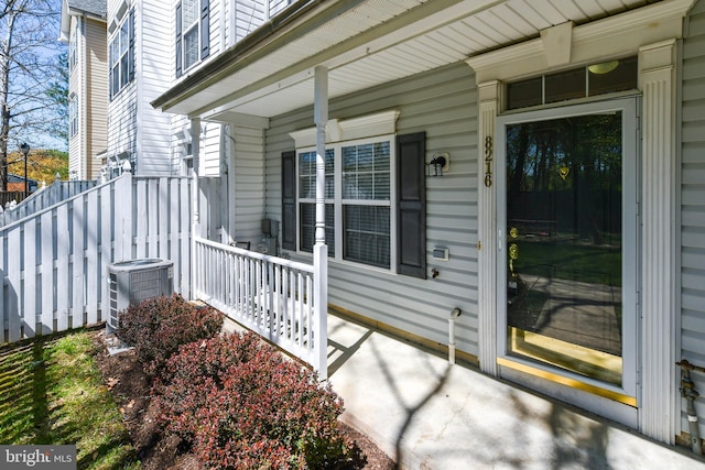 view of exterior entry with a porch and central air condition unit