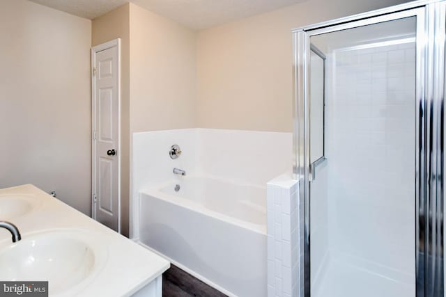 bathroom featuring a bath, a sink, double vanity, and a stall shower