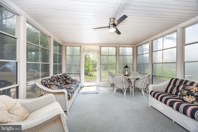 sunroom / solarium with a ceiling fan and an outdoor living space
