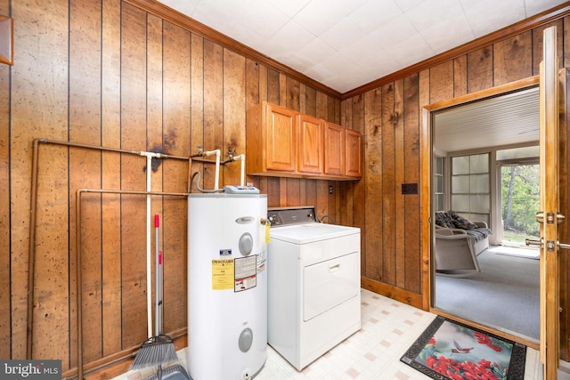 washroom with crown molding, wood walls, washer / dryer, electric water heater, and cabinet space
