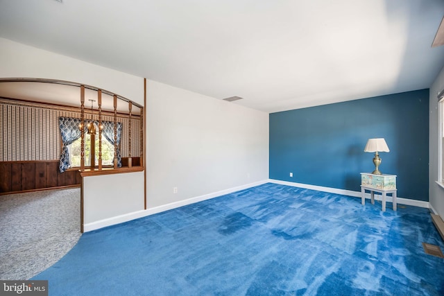 carpeted empty room featuring baseboards and visible vents