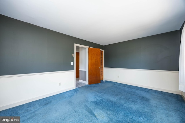 empty room with baseboards and carpet