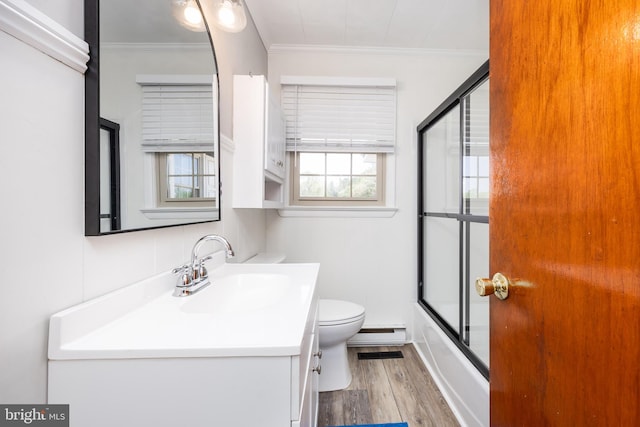 bathroom with crown molding, vanity, wood finished floors, toilet, and a baseboard heating unit