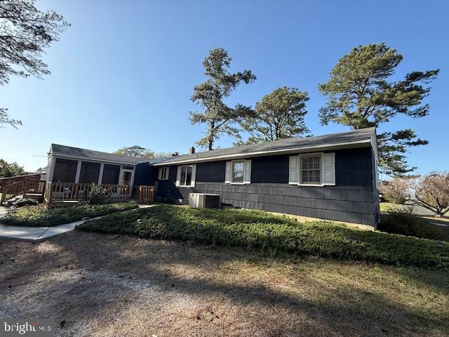 ranch-style house with central air condition unit and a deck