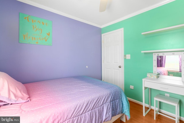 bedroom featuring wood finished floors, crown molding, baseboards, and ceiling fan