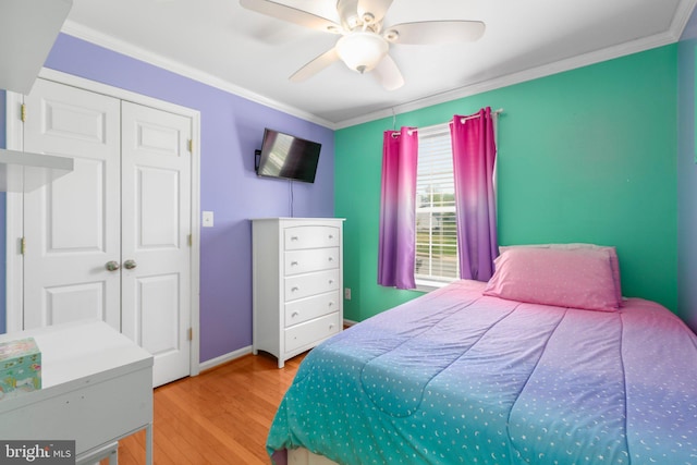 bedroom featuring baseboards, wood finished floors, and ornamental molding