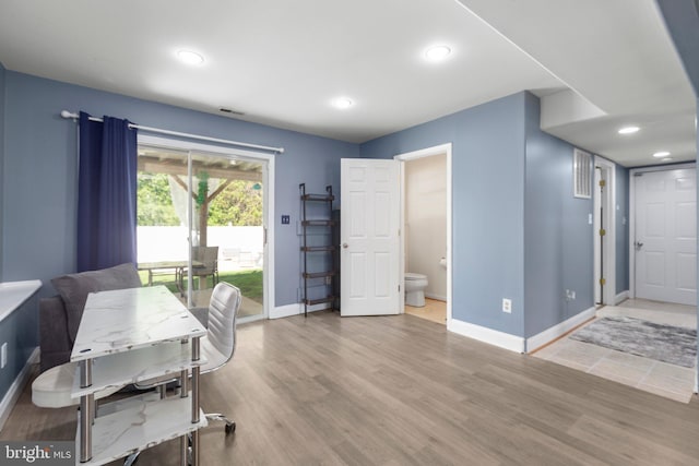 home office featuring wood finished floors, visible vents, and baseboards