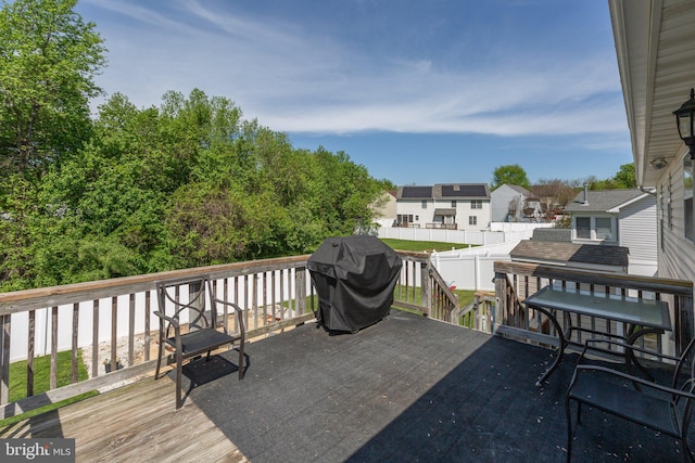 wooden terrace featuring fence, grilling area, and a residential view