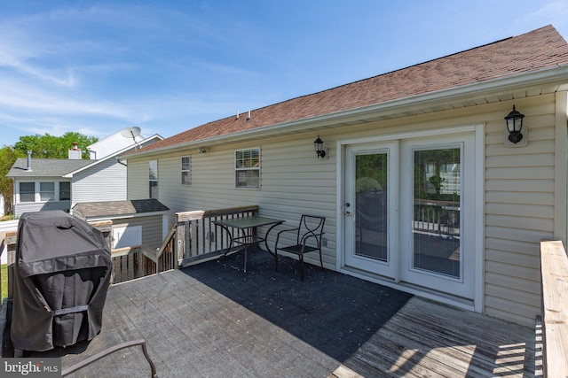 rear view of house with a wooden deck and a shingled roof