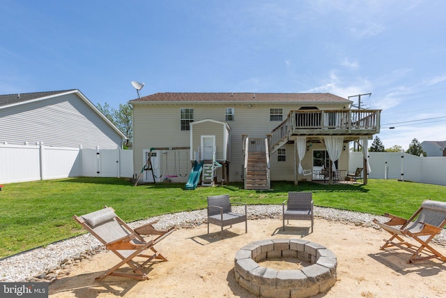 back of property with stairway, a fenced backyard, a fire pit, and a gate
