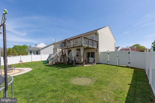 back of property featuring a fenced backyard, a gate, a wooden deck, and stairs