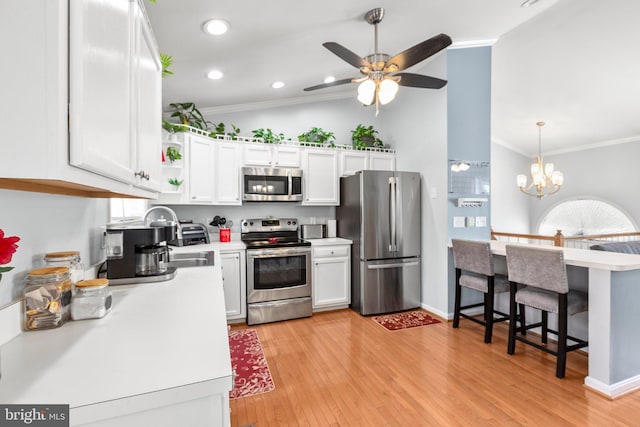 kitchen with light countertops, white cabinetry, appliances with stainless steel finishes, and ornamental molding
