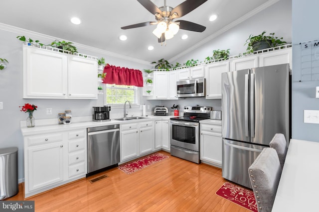 kitchen featuring stainless steel appliances, open shelves, a sink, crown molding, and white cabinetry