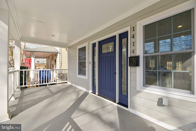view of exterior entry featuring covered porch