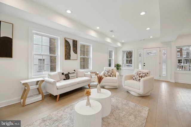 living area with light wood-style floors, baseboards, visible vents, and recessed lighting