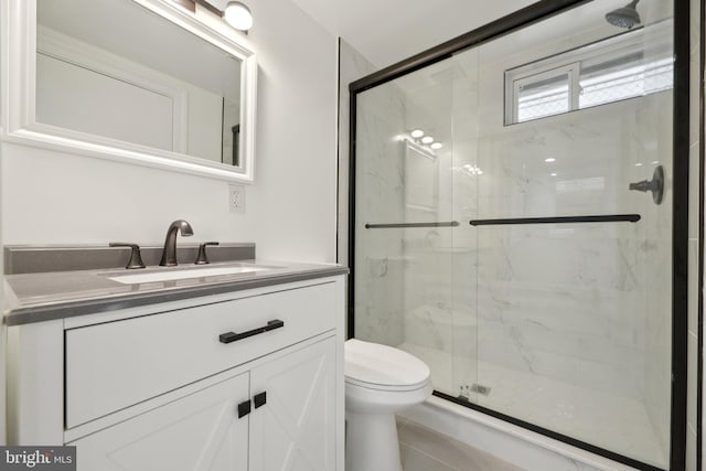 bathroom with toilet, vanity, and a marble finish shower
