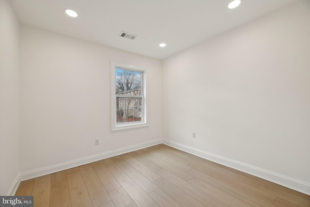 empty room featuring visible vents, baseboards, light wood-type flooring, and recessed lighting