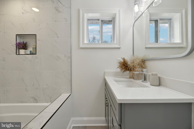 bathroom featuring a healthy amount of sunlight, vanity, and baseboards