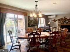 dining space featuring a wall unit AC and wood finished floors