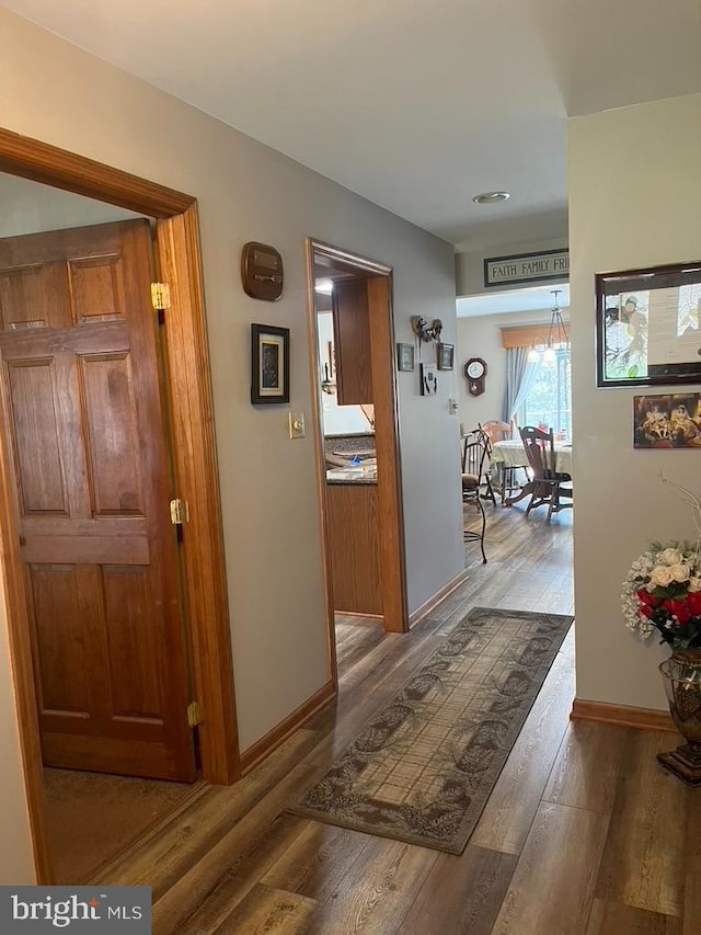hallway featuring baseboards and wood finished floors