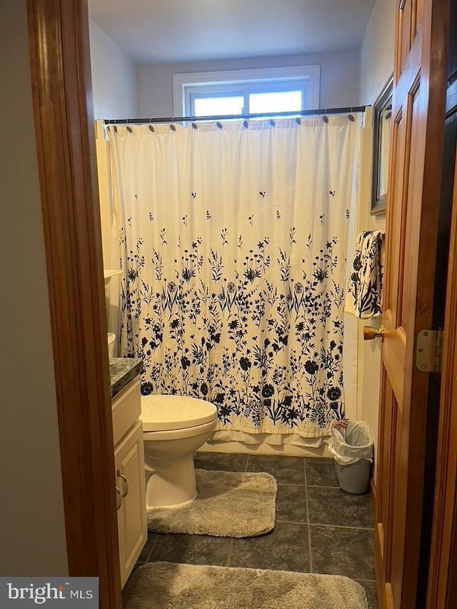 bathroom featuring vanity, toilet, and curtained shower