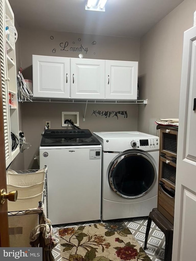 clothes washing area featuring cabinet space and washing machine and clothes dryer