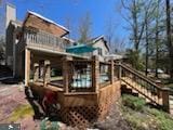 back of house featuring stairs and a deck