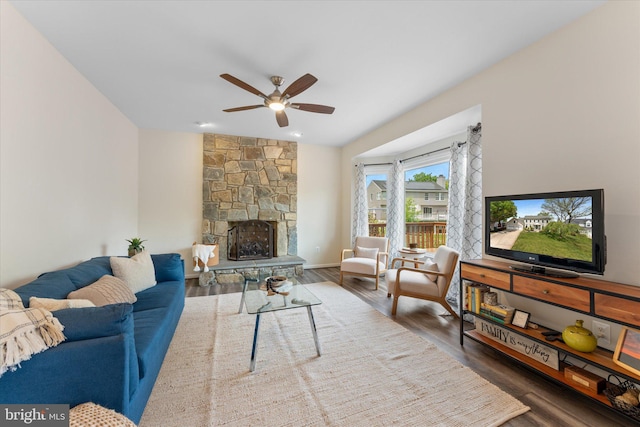 living room featuring a fireplace, wood finished floors, and ceiling fan