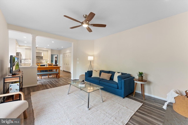 living area featuring baseboards, recessed lighting, decorative columns, dark wood-style floors, and a ceiling fan