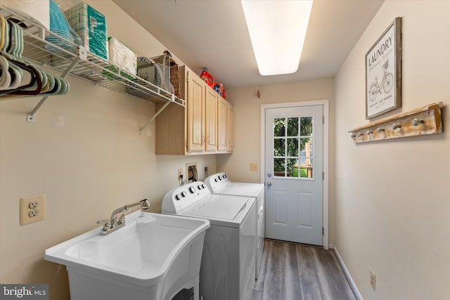 washroom with wood finished floors, separate washer and dryer, cabinet space, a sink, and baseboards