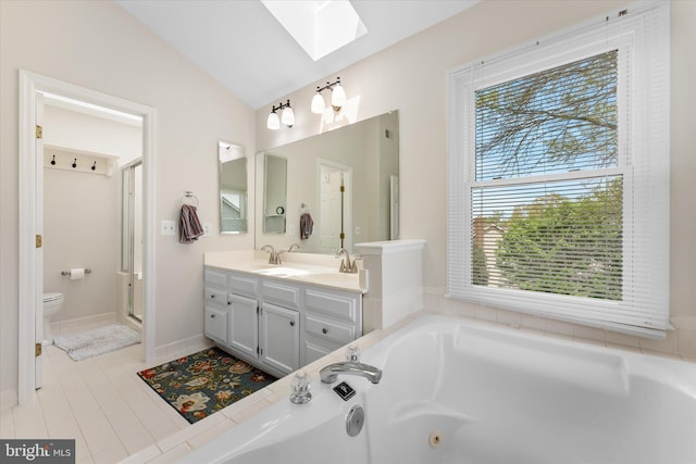full bathroom featuring vaulted ceiling with skylight, double vanity, toilet, a whirlpool tub, and tile patterned flooring