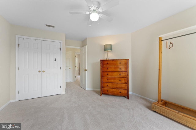 bedroom with a closet, ceiling fan, visible vents, carpet, and baseboards