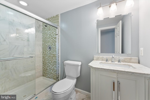 full bath with vanity, toilet, a shower stall, and baseboards