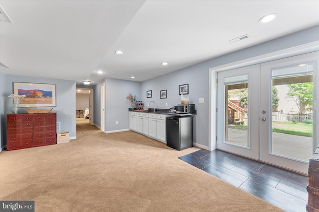 kitchen with fridge, recessed lighting, white cabinetry, and french doors