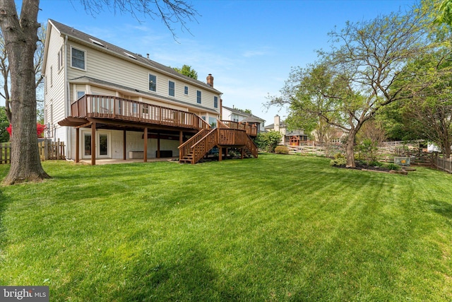 back of property with stairs, a wooden deck, a chimney, fence, and a yard