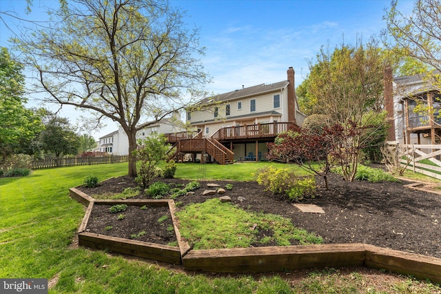 back of property featuring a wooden deck, stairway, a fenced backyard, a lawn, and a vegetable garden