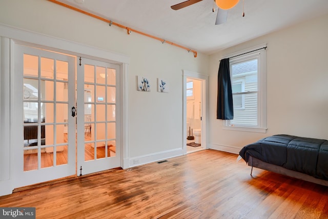bedroom with visible vents, baseboards, connected bathroom, and wood finished floors