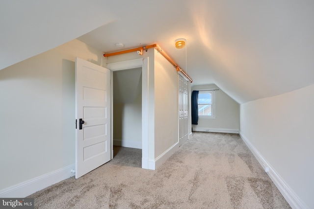 bonus room featuring baseboards, carpet, and vaulted ceiling