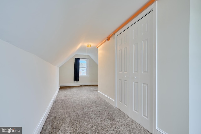 additional living space with carpet flooring, baseboards, and vaulted ceiling