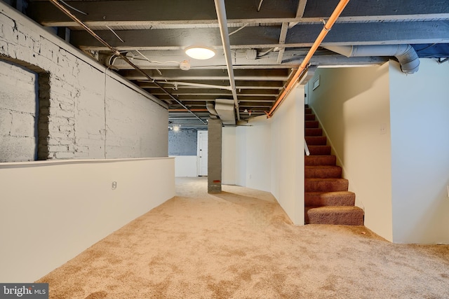 basement with carpet flooring and stairway