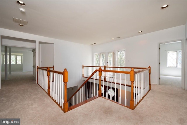 hallway featuring visible vents, an upstairs landing, carpet, and recessed lighting