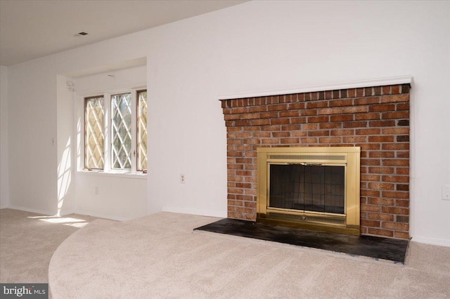 unfurnished living room with a fireplace, visible vents, and carpet floors