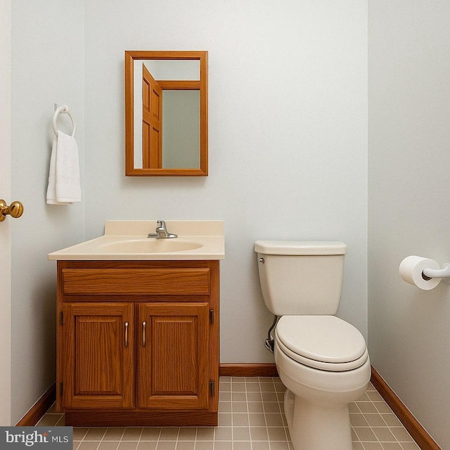 bathroom with tile patterned flooring, vanity, baseboards, and toilet